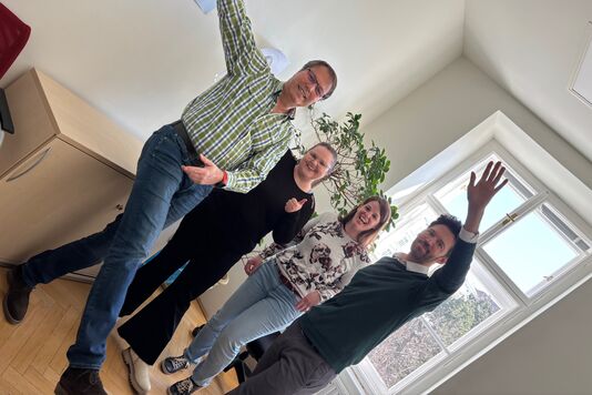 Das Marketing-Team lächelt in die Kamera.