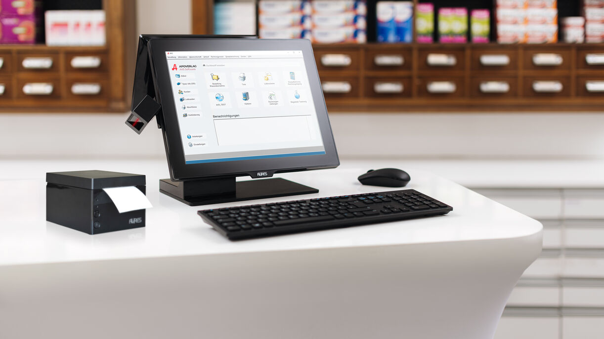 An der Tara in der Apotheke steht ein PC, auf dem der Startbildschirm der AVS-Software zu sehen ist.